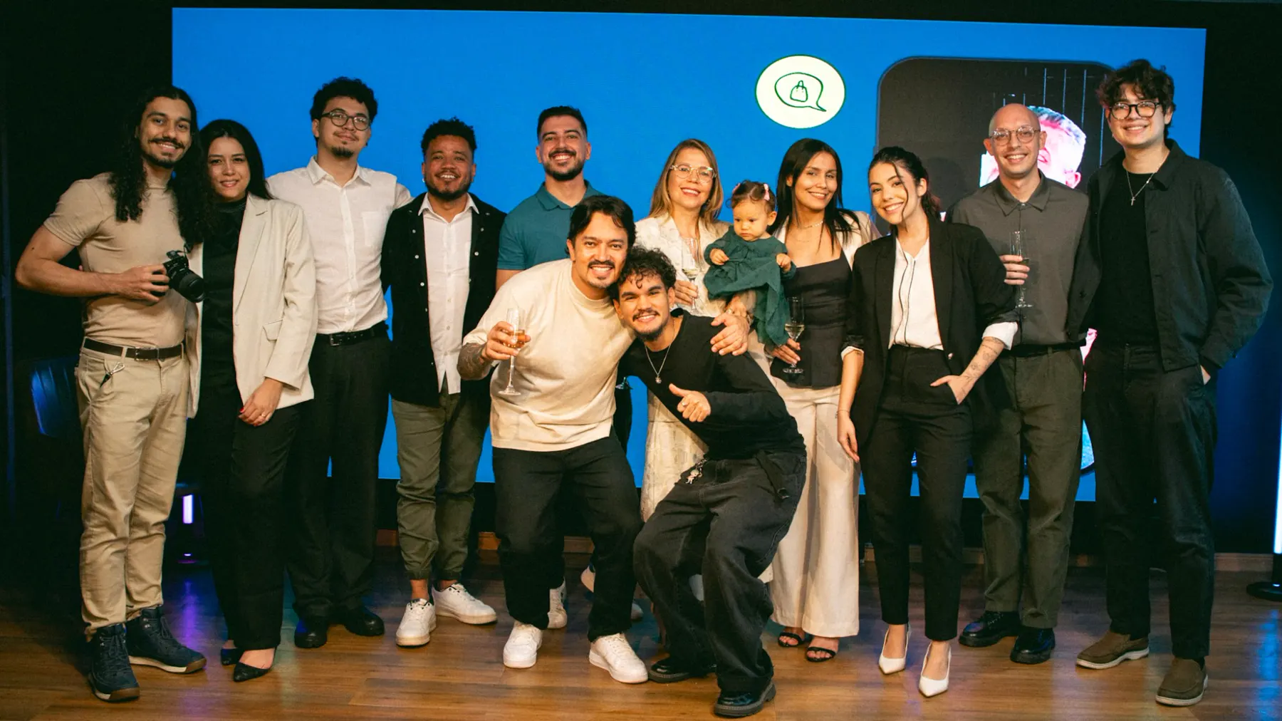 Equipe reunida em frente ao painel de LED